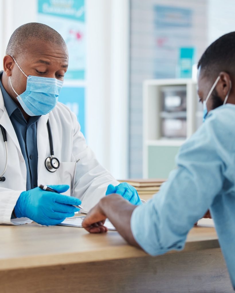 African american doctor talking to a patient in a consult. Doctor and patient talking about their c African american doctor talking to a patient in a consult. Doctor and patient talking about their c