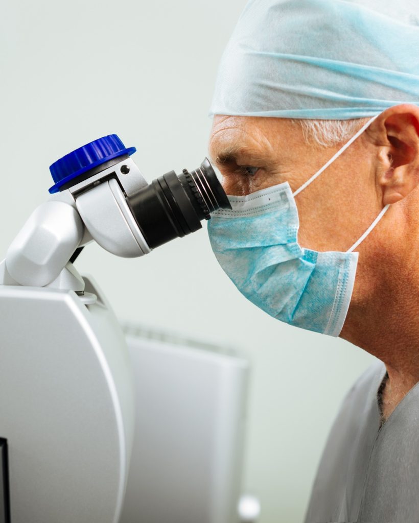 Smart serious doctor looking into the microscope Smart serious doctor looking into the microscope